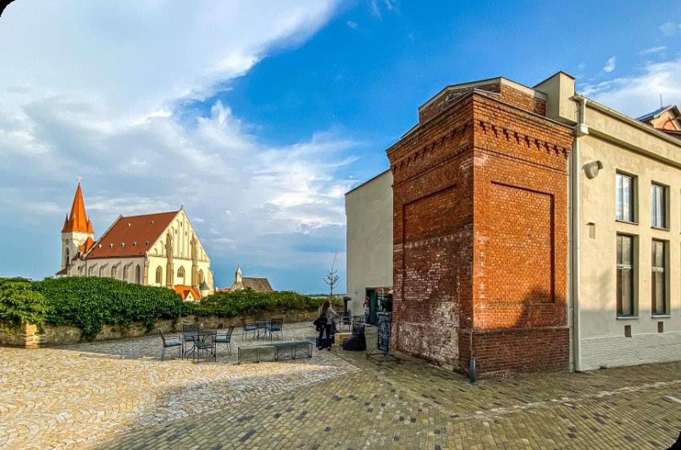 Cihlová budova Enotéky znojemských vín, za ní kostel sv. Mikuláše