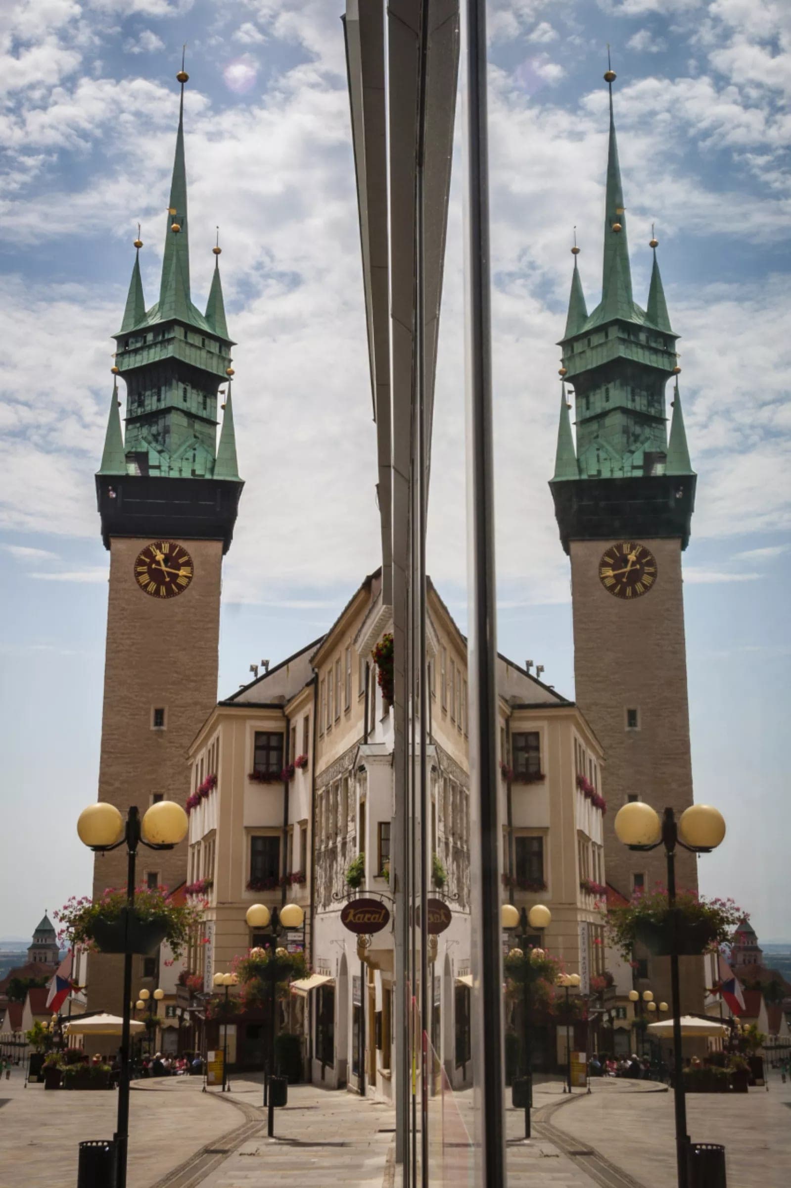 Radniční věž se zrcadlí v prosklené fasádě