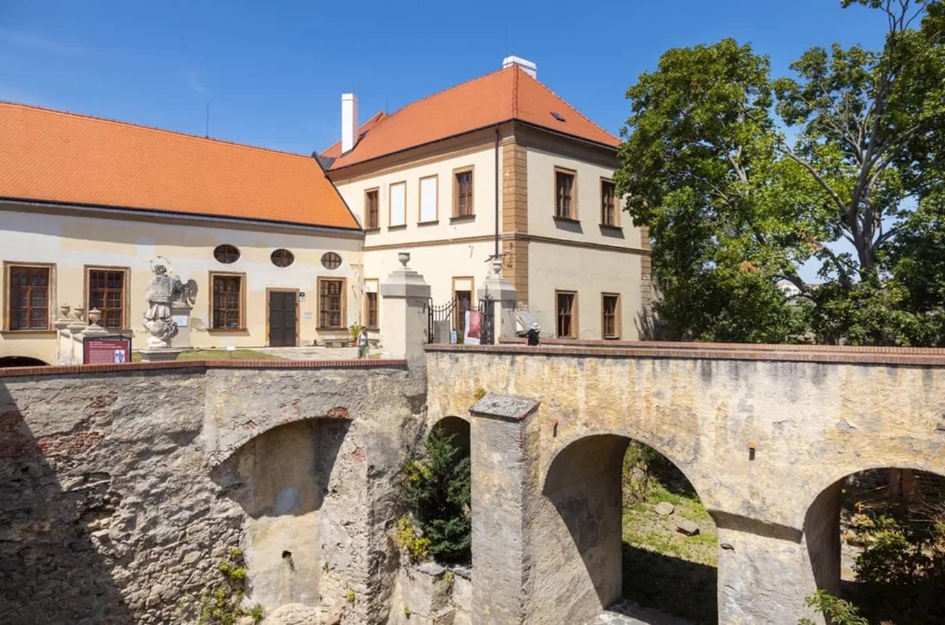 Znojemský hrad — barokní zámecká budova a kamenný most přes příkop