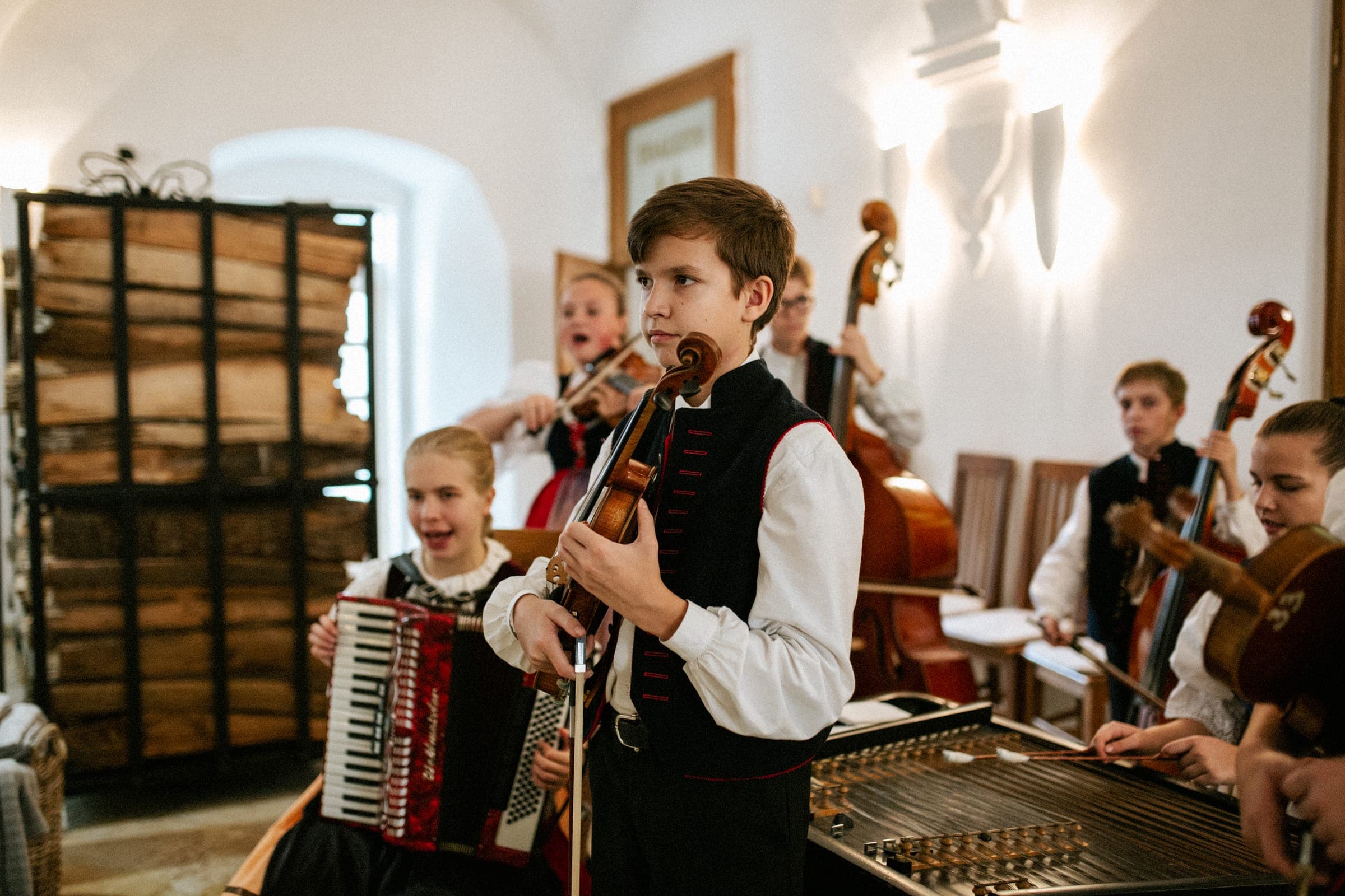 Dětská cimbálová muzika v krojích hraje v klenuté místnosti